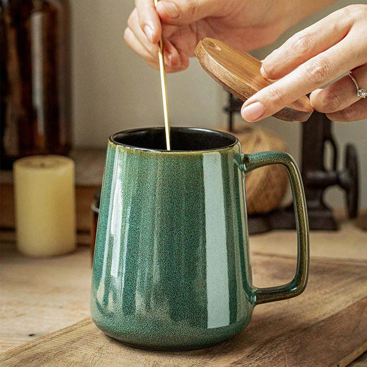 Green ceramic mug with spoon on a wooden surface