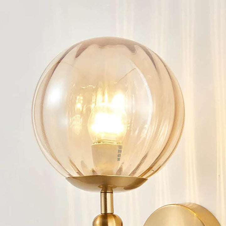 Amber glass globe wall light with warm LED bulb, MAELKEBOLD modern sconce for soft ambient bedroom or UK  hallway lighting.