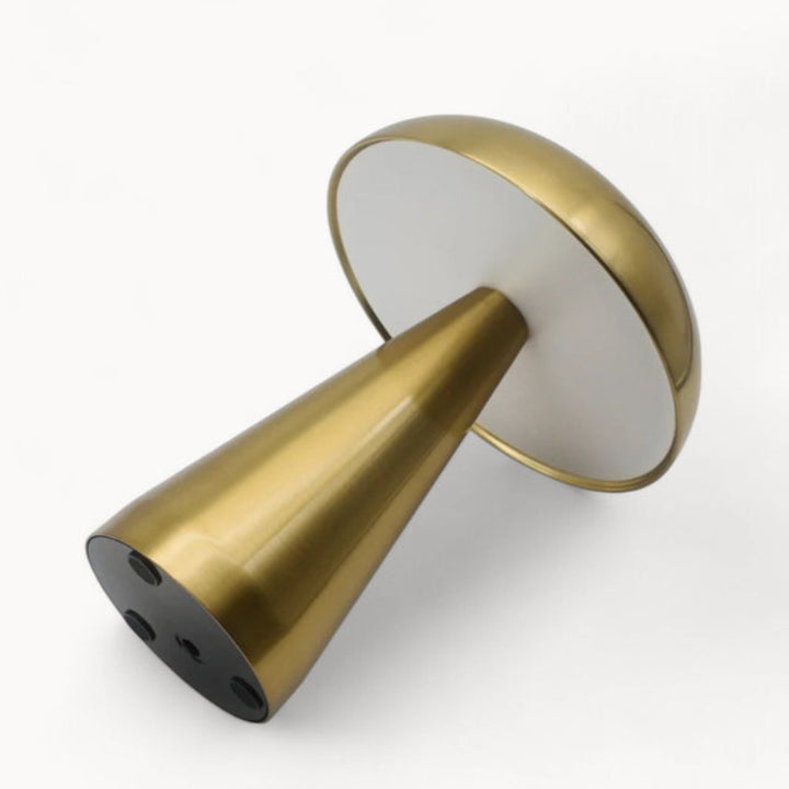 Underside view of brushed gold rechargeable table lamp showing flat base and conical shape.