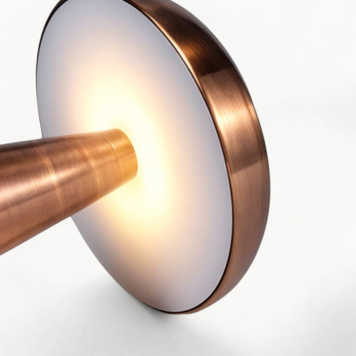 Warm light glowing from underside of brushed copper rechargeable table lamp.