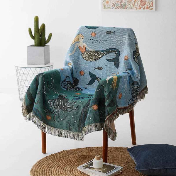 Mermaid pattern throw blanket on a bedspread, adding a playful, artistic touch to decor.