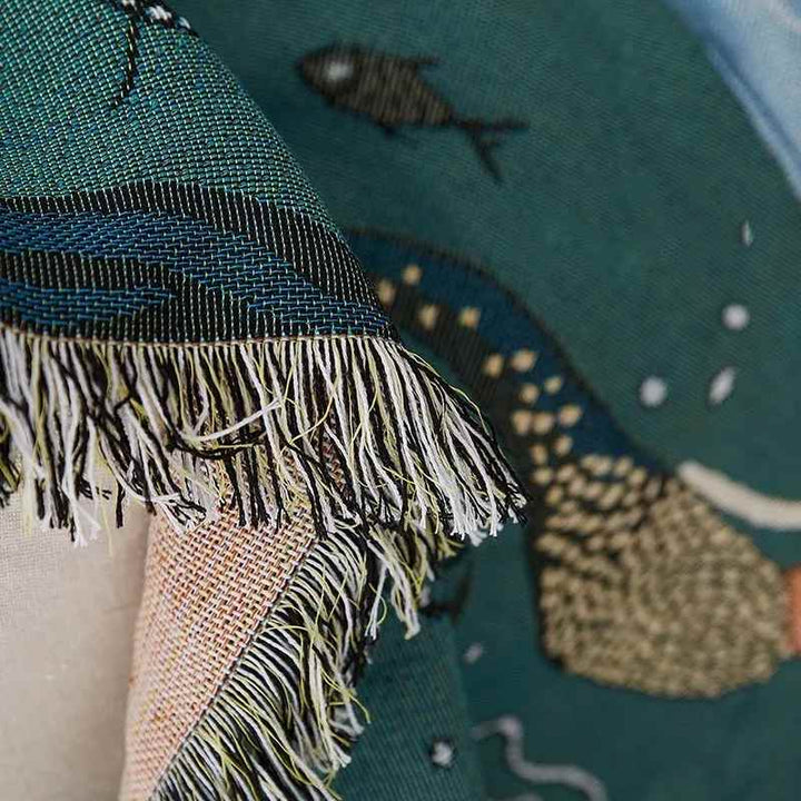 Close-up of a mermaid pattern throw blanket, showing the gentle texture and playful motif.