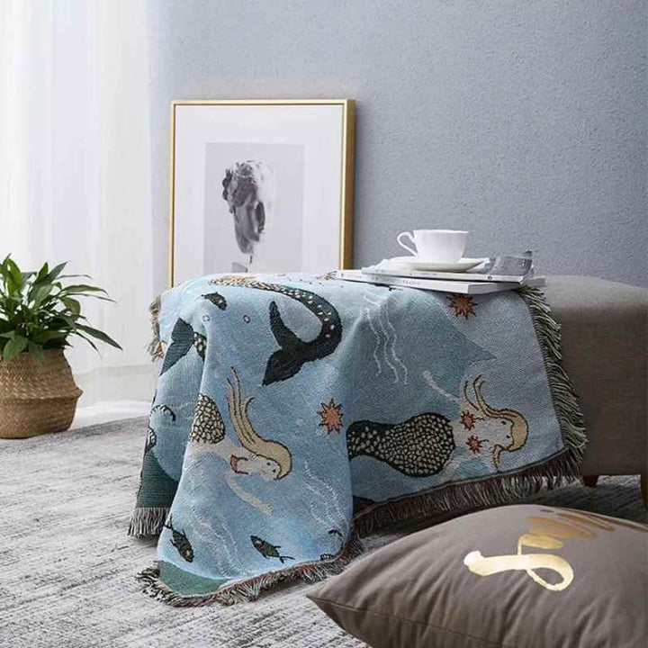 Cozy mermaid pattern blanket on a sofa, a machine washable cotton blend textile for everyday use.