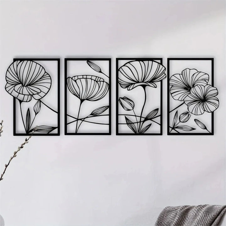Set of four black floral wall art panels on a white wall.