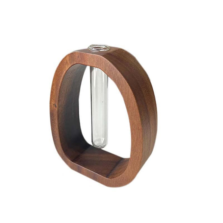 Wooden ring with a clear cylindrical object inside on a white background
