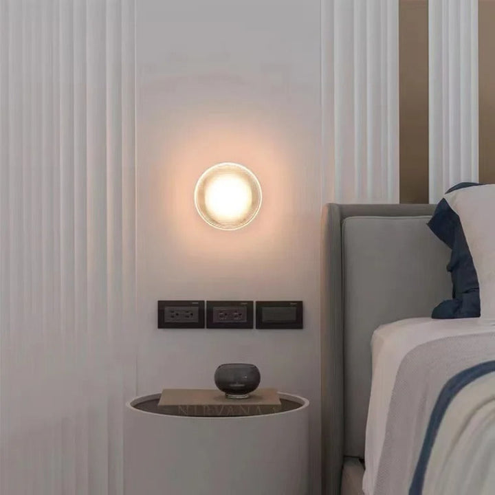 Wooden staircase with wall-mounted lights on a gray wall.