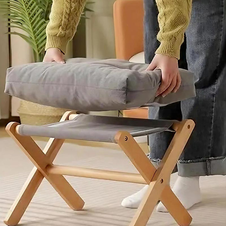 Detachable cushion lifted from foldable wooden frame, showing easy storage and soft cotton padding for Nordic interiors.