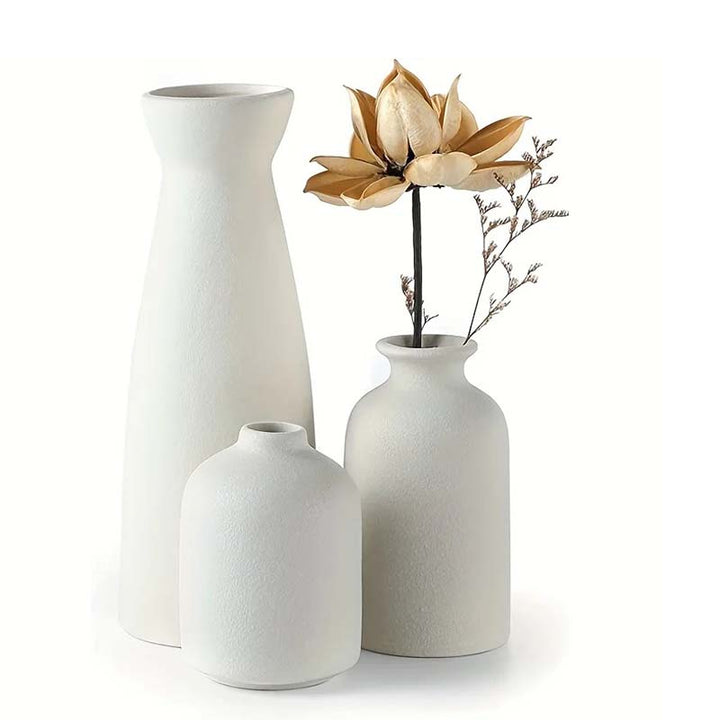 Three white vases of different sizes with a gold flower on a white background