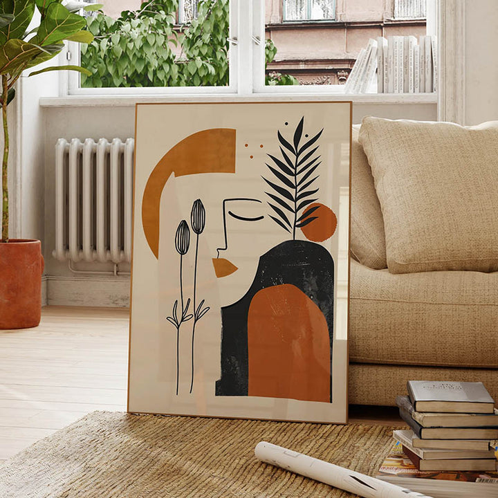 Framed abstract art print featuring minimal line drawing and organic shapes in earthy tones, styled in a cosy modern living space.