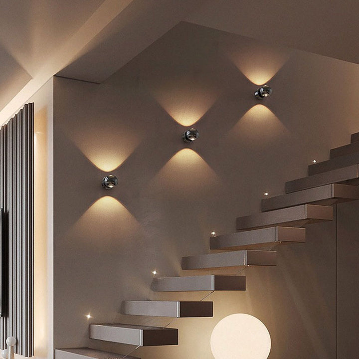 Set of black Nordic-style LED wall lights installed along a staircase, creating a striking geometric lighting effect for a contemporary home setting.
