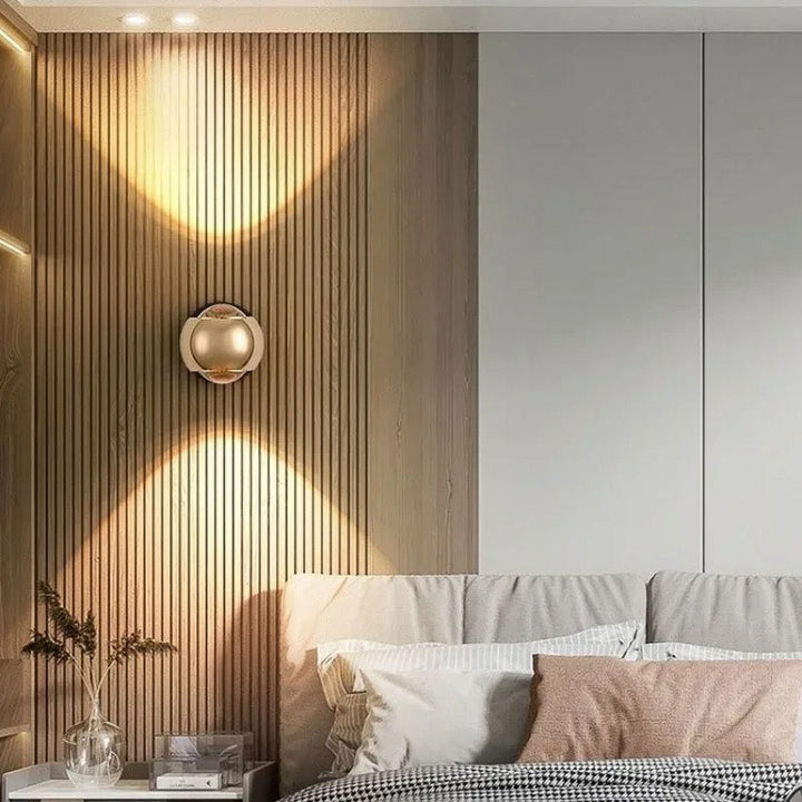 Goldadjustable LED wall light mounted in a modern bedroom, casting soft up-and-down lighting for a warm and elegant ambience.