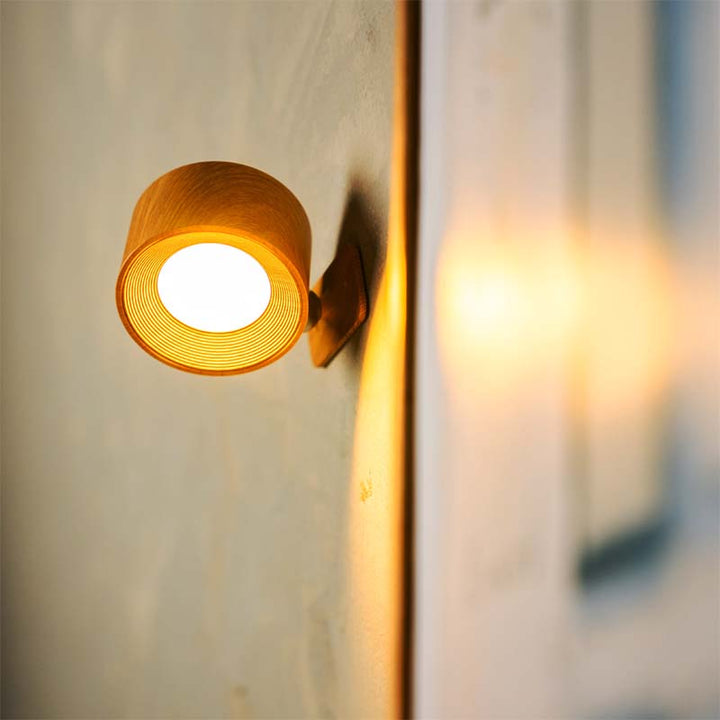 Wall-mounted light fixture on a neutral wall with a blurred background