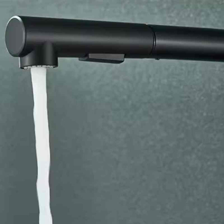 Matte black kitchen faucet spout releasing steady stream in standard water flow mode.