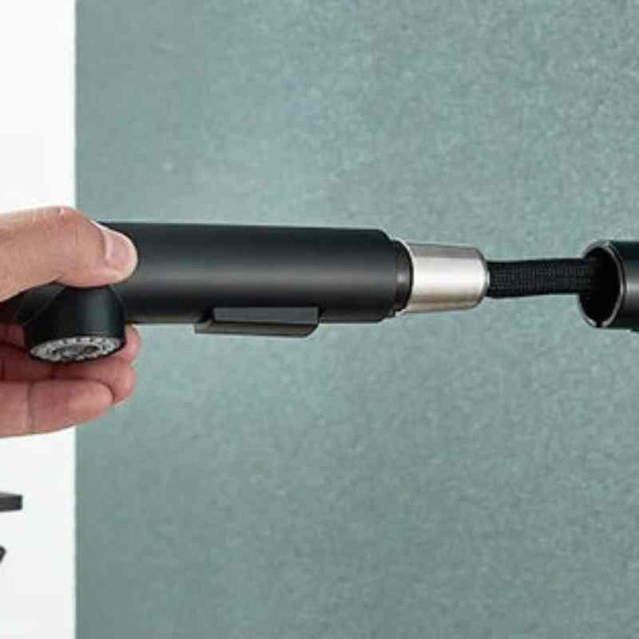 Close-up of detachable pull-out sprayer in matte black kitchen faucet design.