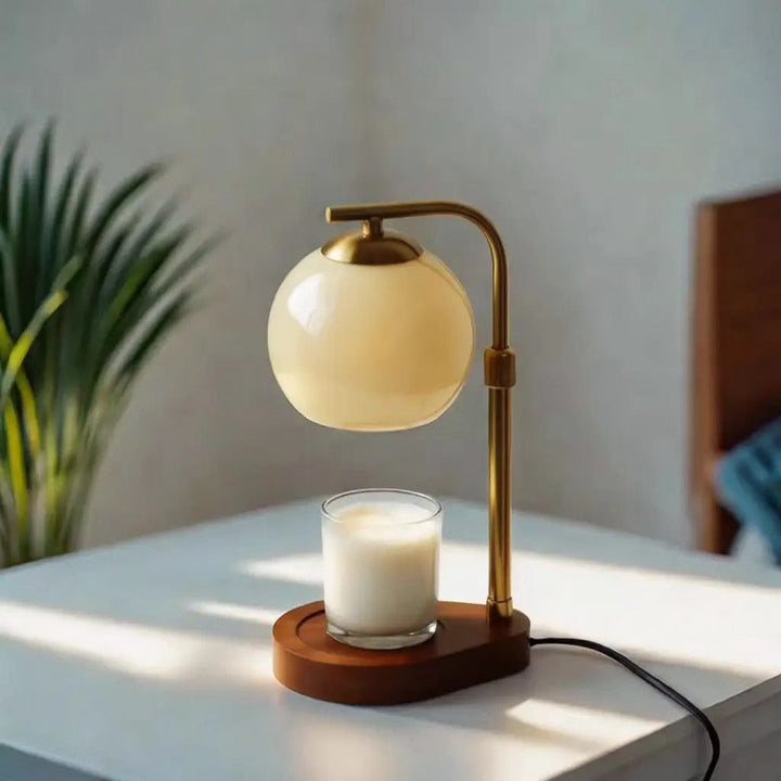 Table lamp with a candle warmer on a wooden base in a softly lit room.