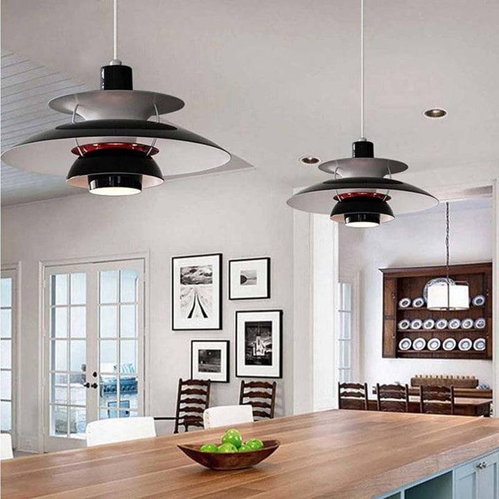 Modern Nordic black pendant lights hanging above a dining table in a well-lit room.