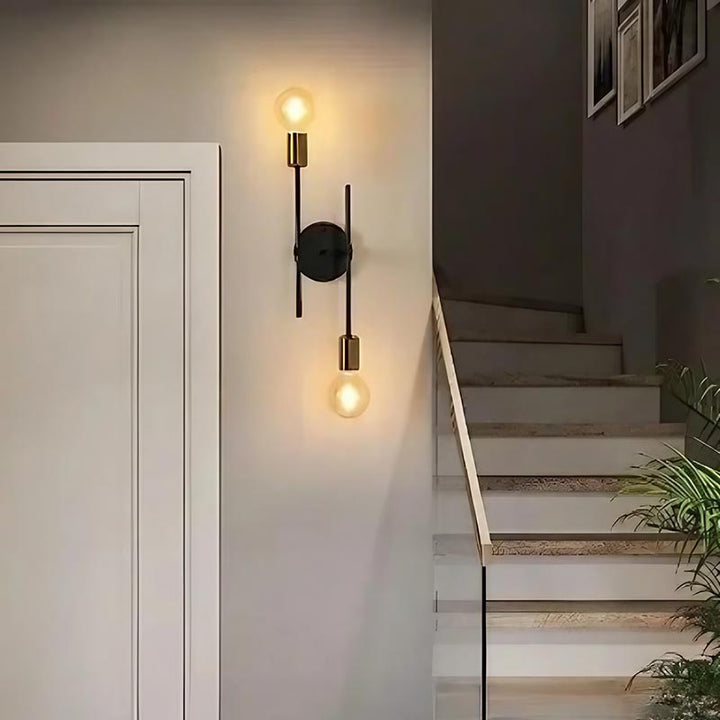 Modern black and gold wall light on staircase wall, versatile fixture used as ceiling or sconce lighting