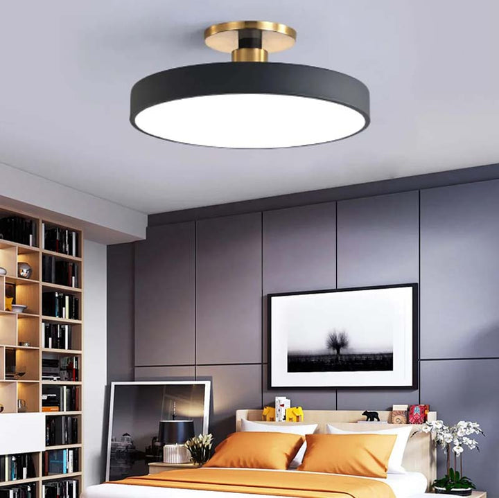 Modern bedroom with a black and gold ceiling light fixture.