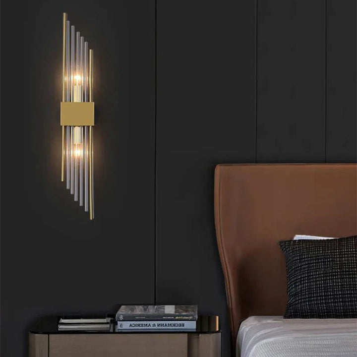 Gold crystal LED wall light mounted on dark wall in UK bedroom with modern headboard and minimalist decor
