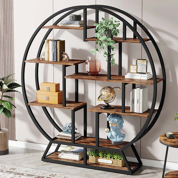 Round bookshelf with wooden shelves and decorative items against a white wall.
