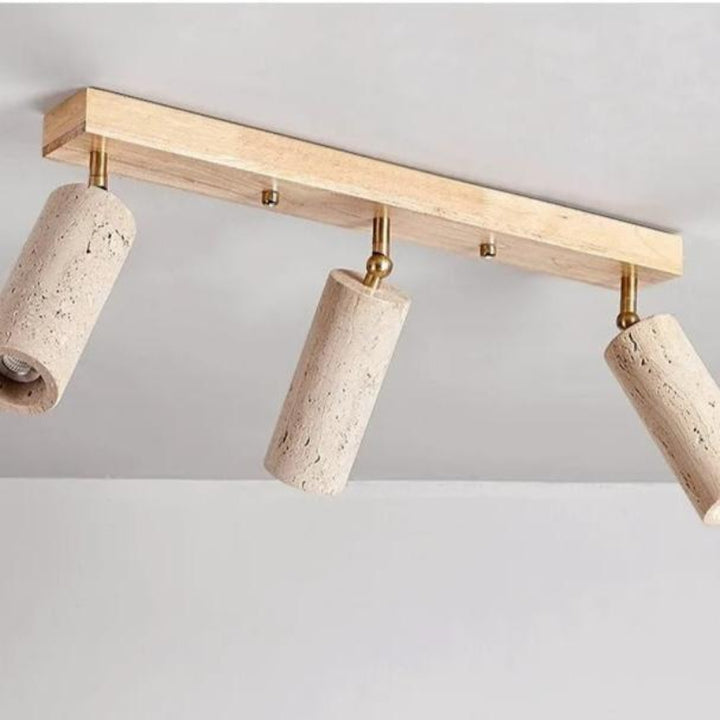 Ceiling light fixture with three cylindrical stone-like lampshades on a plain background
