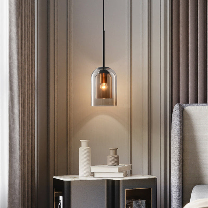 Amber glass pendant lamp hanging beside a modern bed