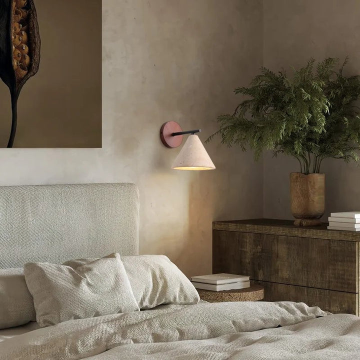 Natural stone wall light above bed in Japandi-style UK bedroom with textured headboard and minimalist decor.