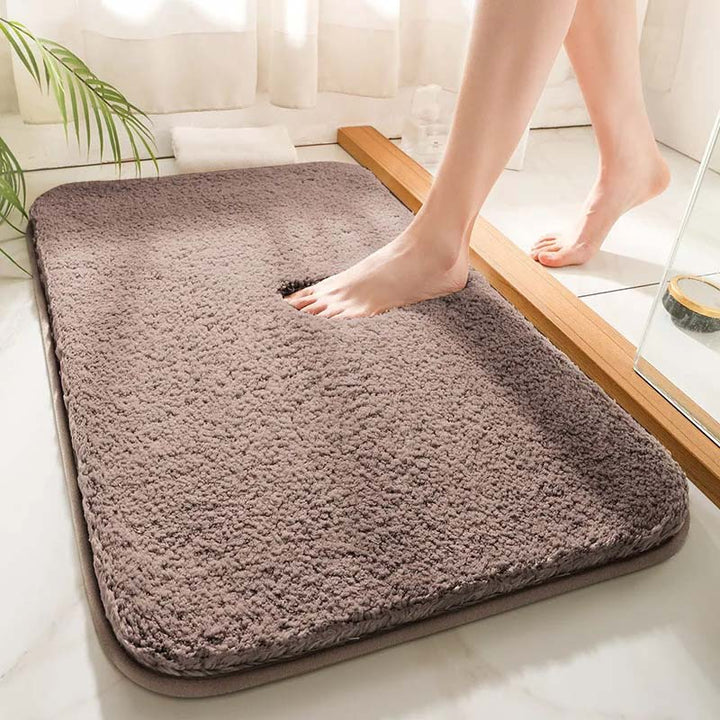 Person stepping onto a fluffy brown bath mat in a bathroom setting.