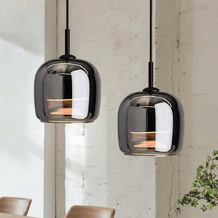 Two modern dimmable pendant lights hanging against a neutral wall.
