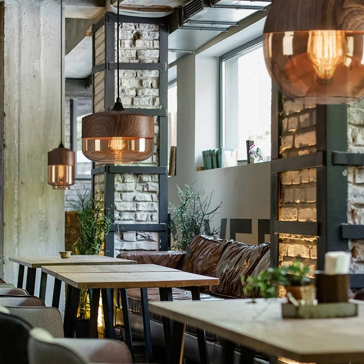 Modern restaurant interior with wooden tables, pendant lights, and decorative elements.
