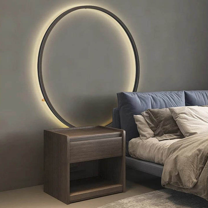 Cosy Scandinavian-style interior with large KRETS LED ring lamp creating atmospheric lighting above bed