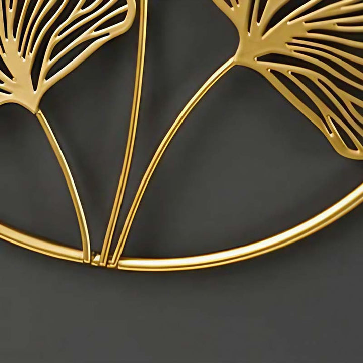Close-up of gold metal ginkgo leaf wall art on black background, modern Nordic wall decor for living room or hallway.