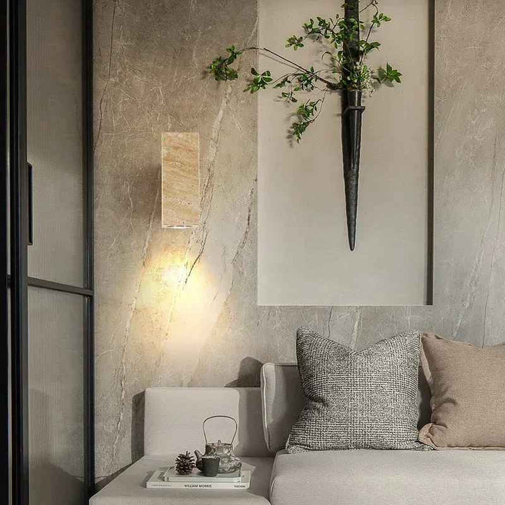 Modern interior with a gray sofa, decorative pillows, Nordic Wall Lamp and a wall sconce with greenery.