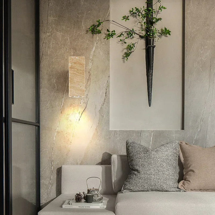 Modern interior with a gray sofa, decorative pillows, Nordic Wall Lamp and a wall sconce with greenery.