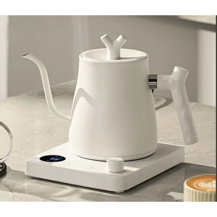 White electric kettle on a white surface with a blurred background