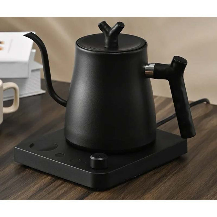 Black electric kettle on a wooden surface with a blurred background
