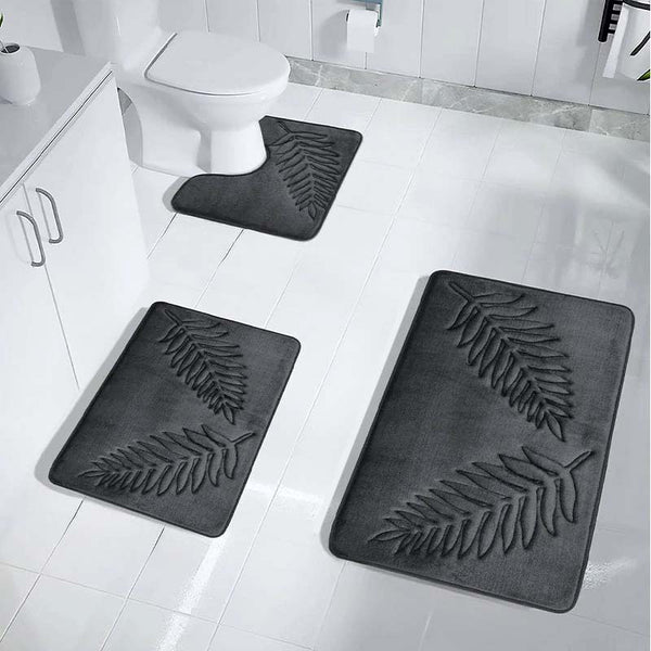Black bath mats with leaf pattern on a bathroom floor