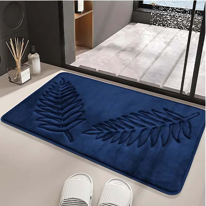 Navy textured bathroom rug on a light-colored floor with white shoes nearby.