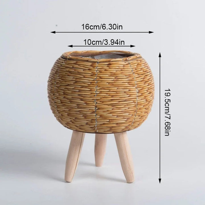 Round rattan plant basket with short wood legs, natural finish, styled with succulents, Nordic Essentials 