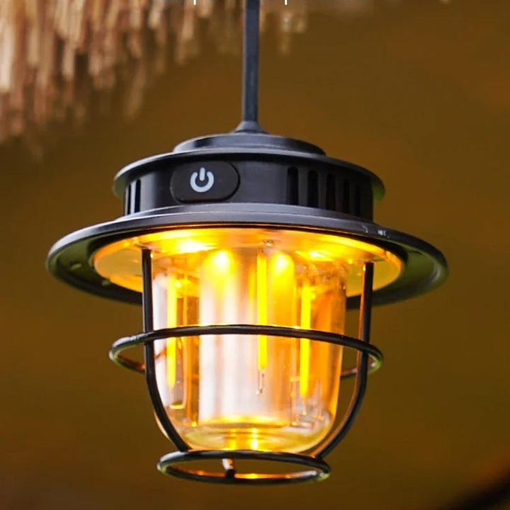 Black retro-style rechargeable camping lantern with warm amber LED light and silicone hanging hook, perfect for tents and patios
