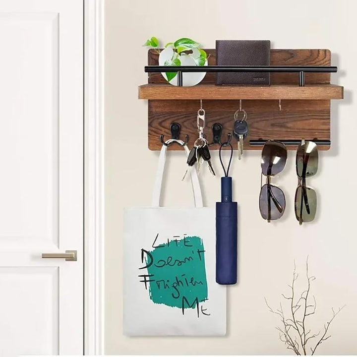 Wall-mounted wooden key holder with black hooks and shelf, ideal for post, plants, and entryway organisation.