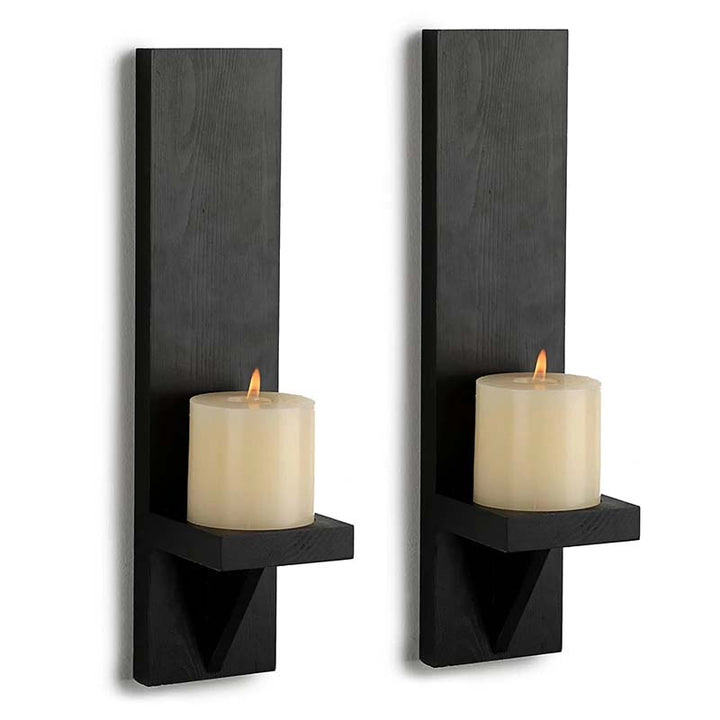 Two black wall sconces with candles on a white background