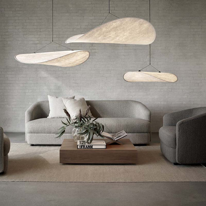 Modern living room with gray sofa, wooden coffee table, and pendant lights.