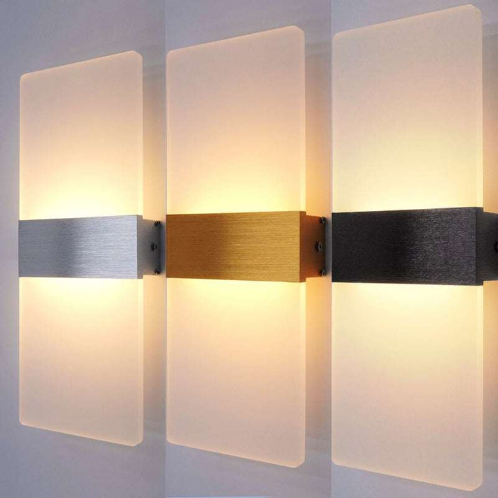 Three modern LED wall lamps side by side with brushed aluminium, gold, and black center strips, showing different finish options.