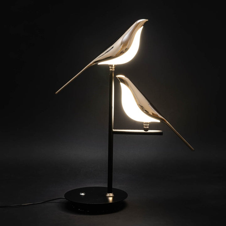 Artistic golden bird LED lamp on black base, symbolizing modern minimalist style.