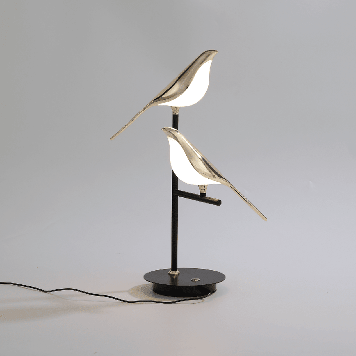 Artistic golden bird LED lamp on black base, symbolizing modern minimalist style.