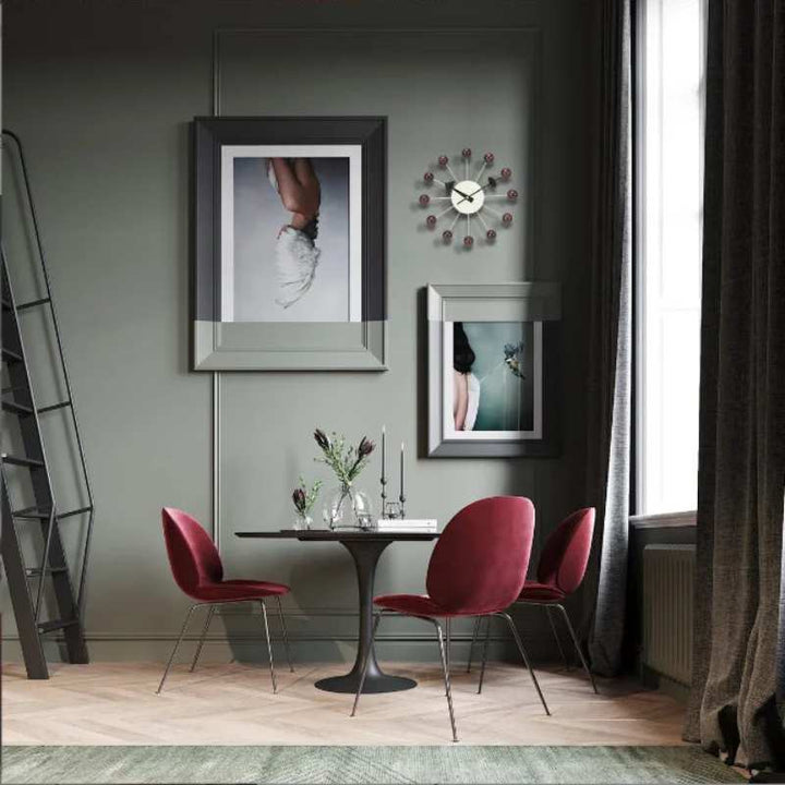 Brushed metal wall clock with orange, green, black, and white ball accents for modern interiors