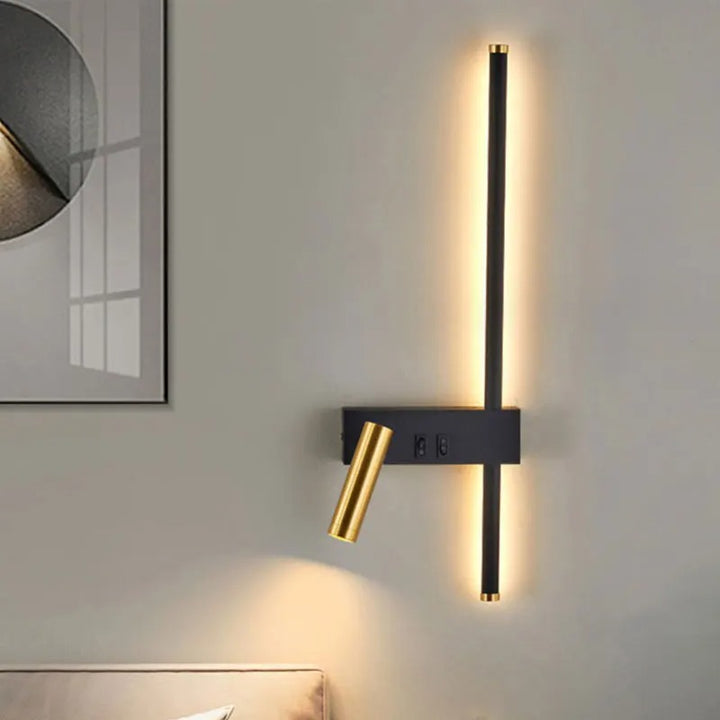 Modern wall-mounted LED lamp with black vertical light bar and adjustable gold spotlight above bed
