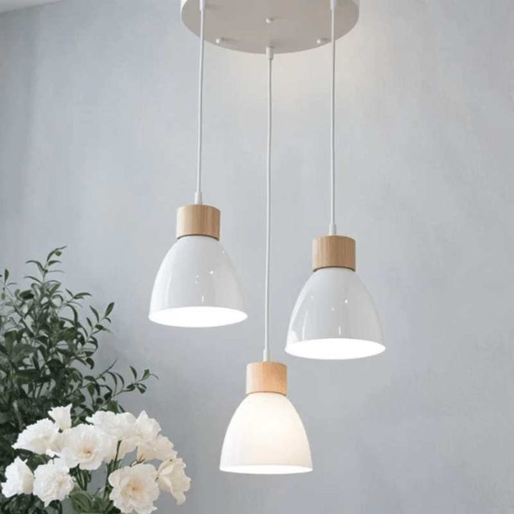 Cluster of three glossy white pendant lights with wooden accents on round ceiling mount