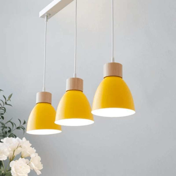 Three yellow pendant lights with wood detail on rectangular ceiling base